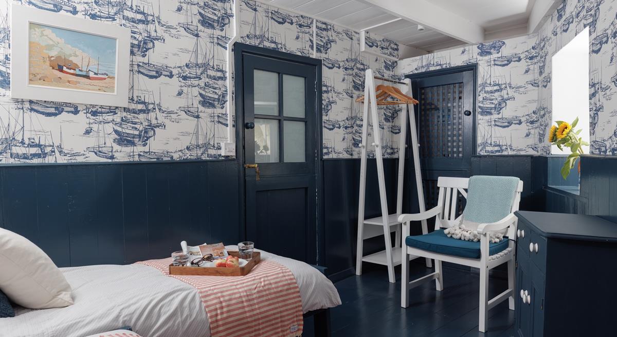 The twin room is decorated with fun nautical wallpaper.