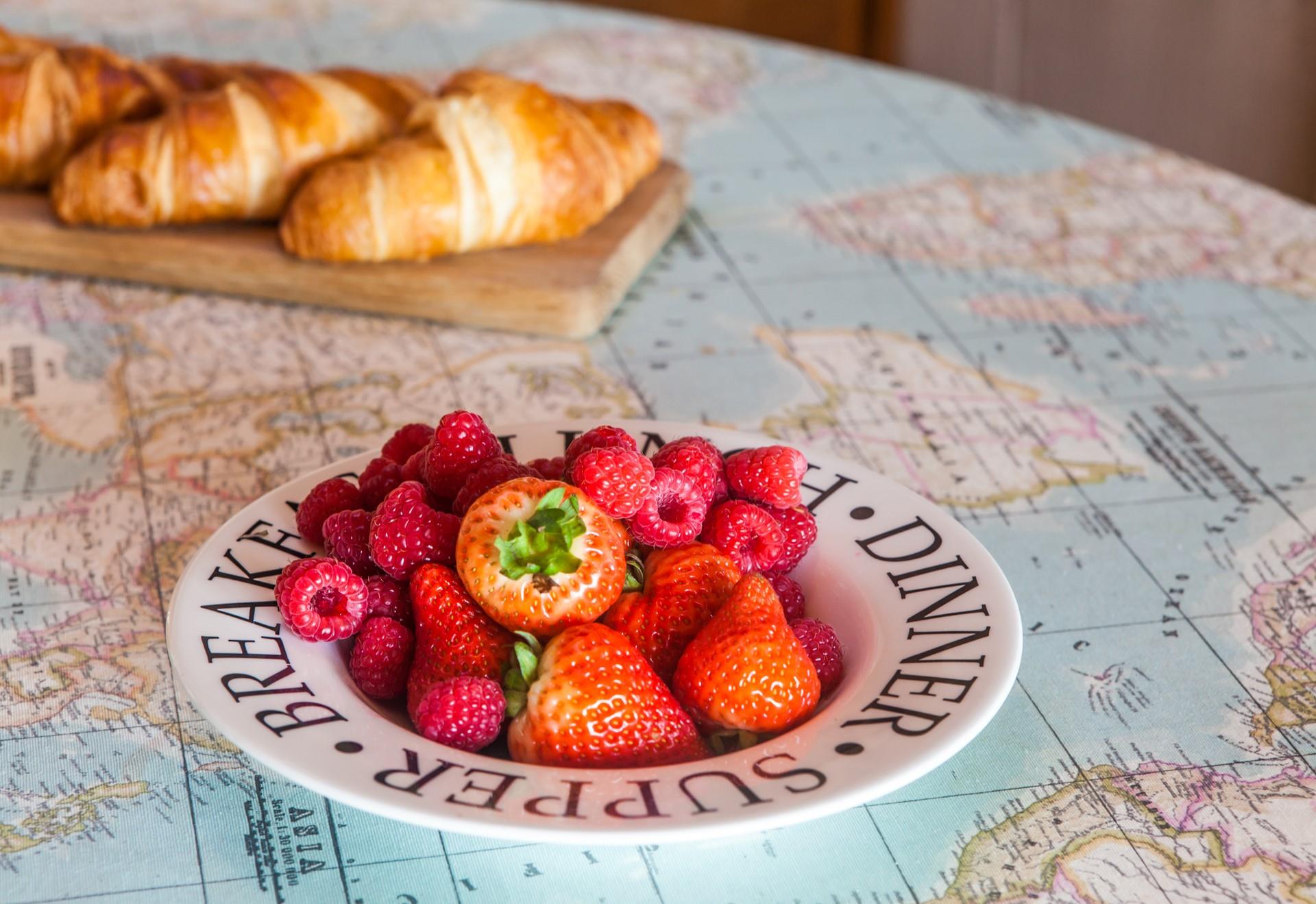 Indulge in a breakfast of croissants generously coated with Cornish butter and topped with fresh fruit.