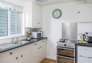 The kitchen is well-equipped with a microwave, electric oven and hob, washing machine and fridge/freezer. 