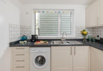 The kitchen is well-equipped with a microwave, electric oven and hob, washing machine and fridge/freezer. 