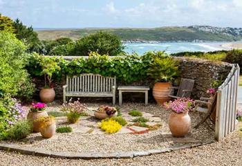 The courtyard area has seating and stunning views of Crantock Bay.