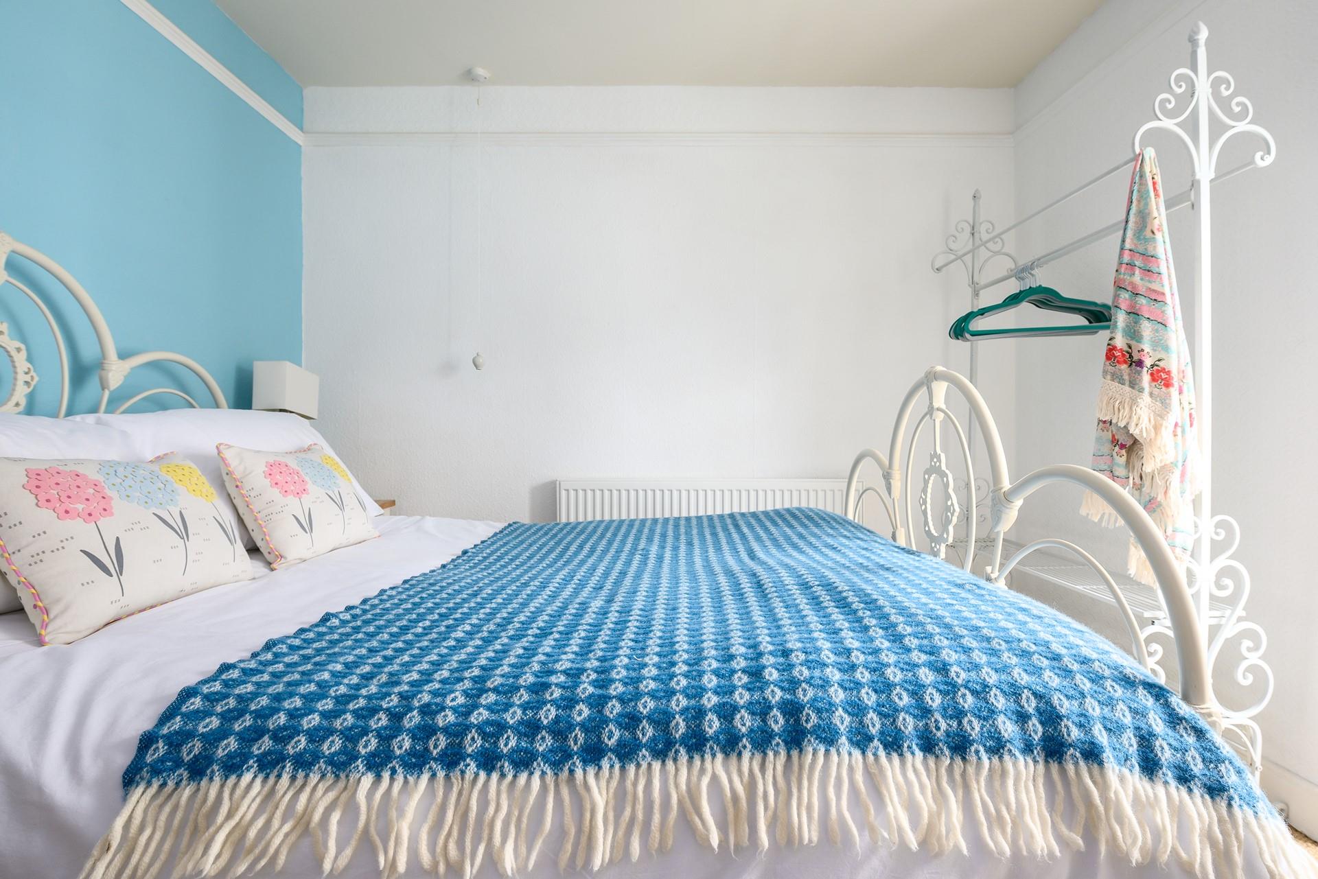 The sky blue wall adds a pop of colour to the bedroom.