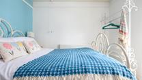 The sky blue wall adds a pop of colour to the bedroom.