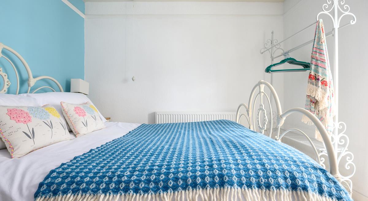 The sky blue wall adds a pop of colour to the bedroom.