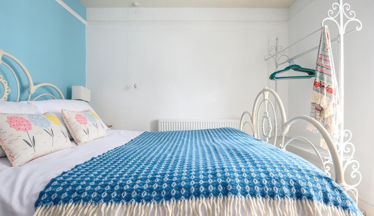The sky blue wall adds a pop of colour to the bedroom.