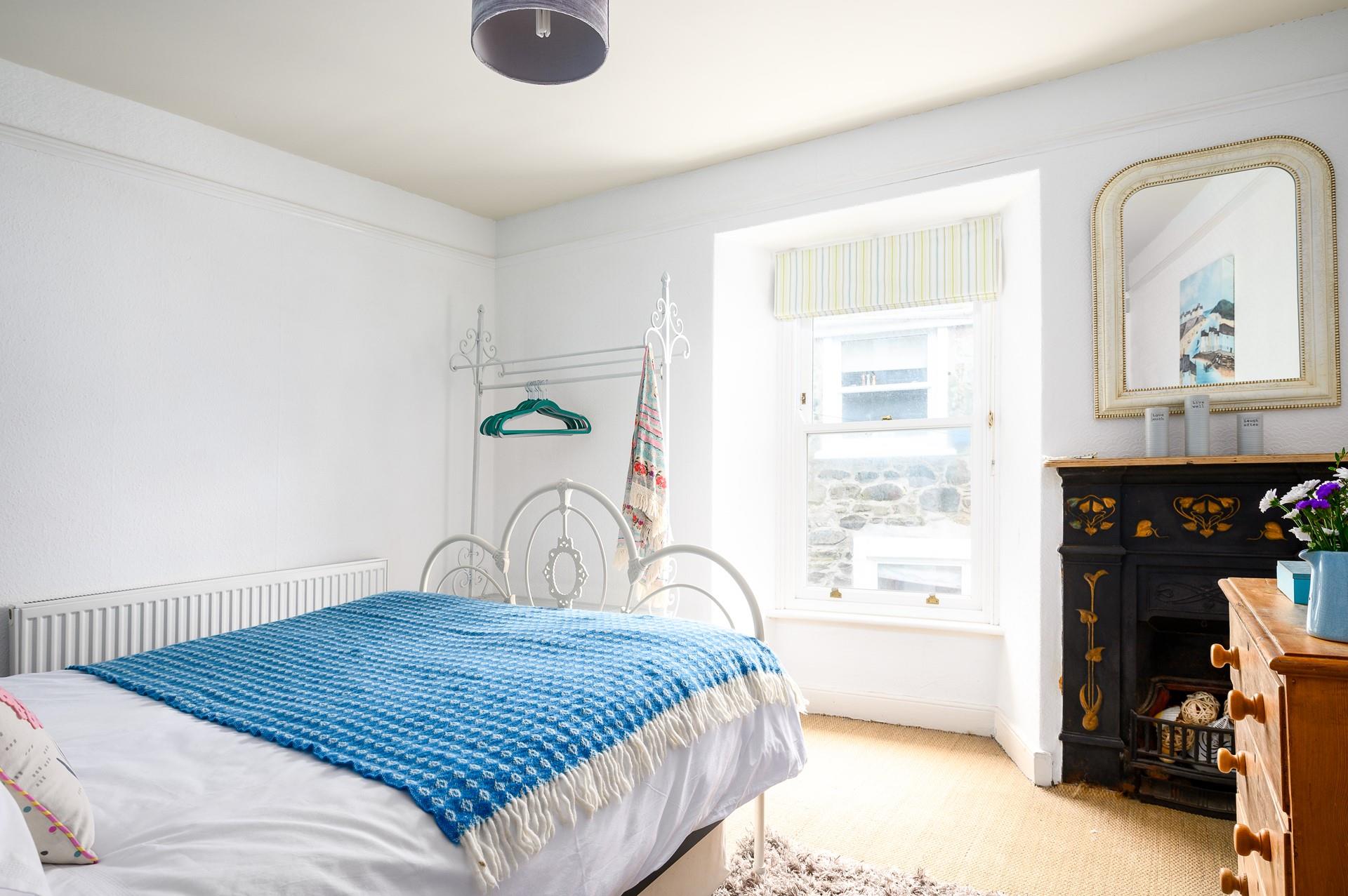 The bedroom has traditional features such as the original feature fireplace in the bedroom.