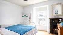 The bedroom has traditional features such as the original feature fireplace in the bedroom.