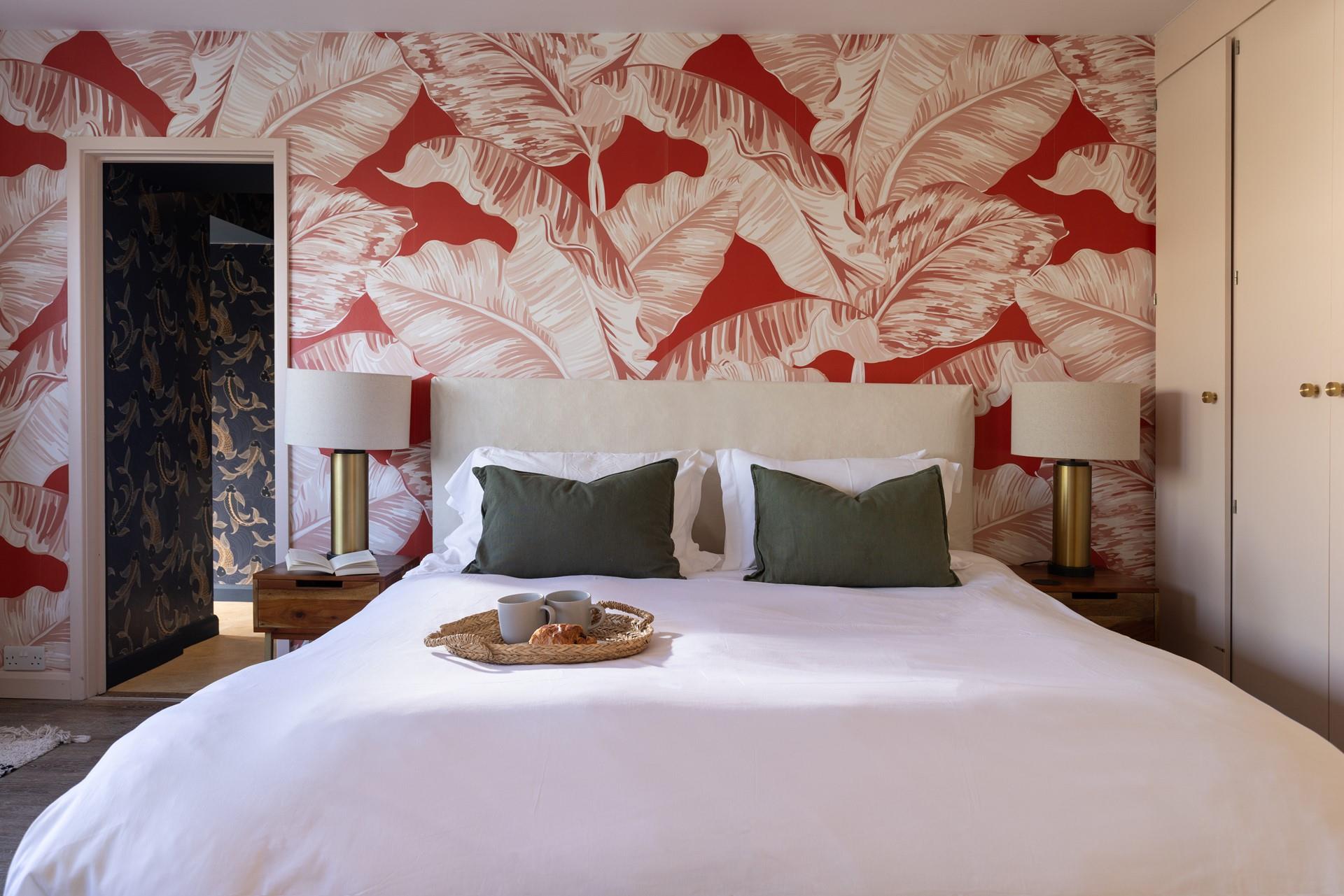 We love the pale pink bedroom and tropical wallpaper.