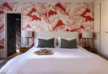 We love the pale pink bedroom and tropical wallpaper.