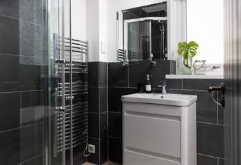 A monochromatic colour palette and modern fixtures give the bathroom a stylish feel.