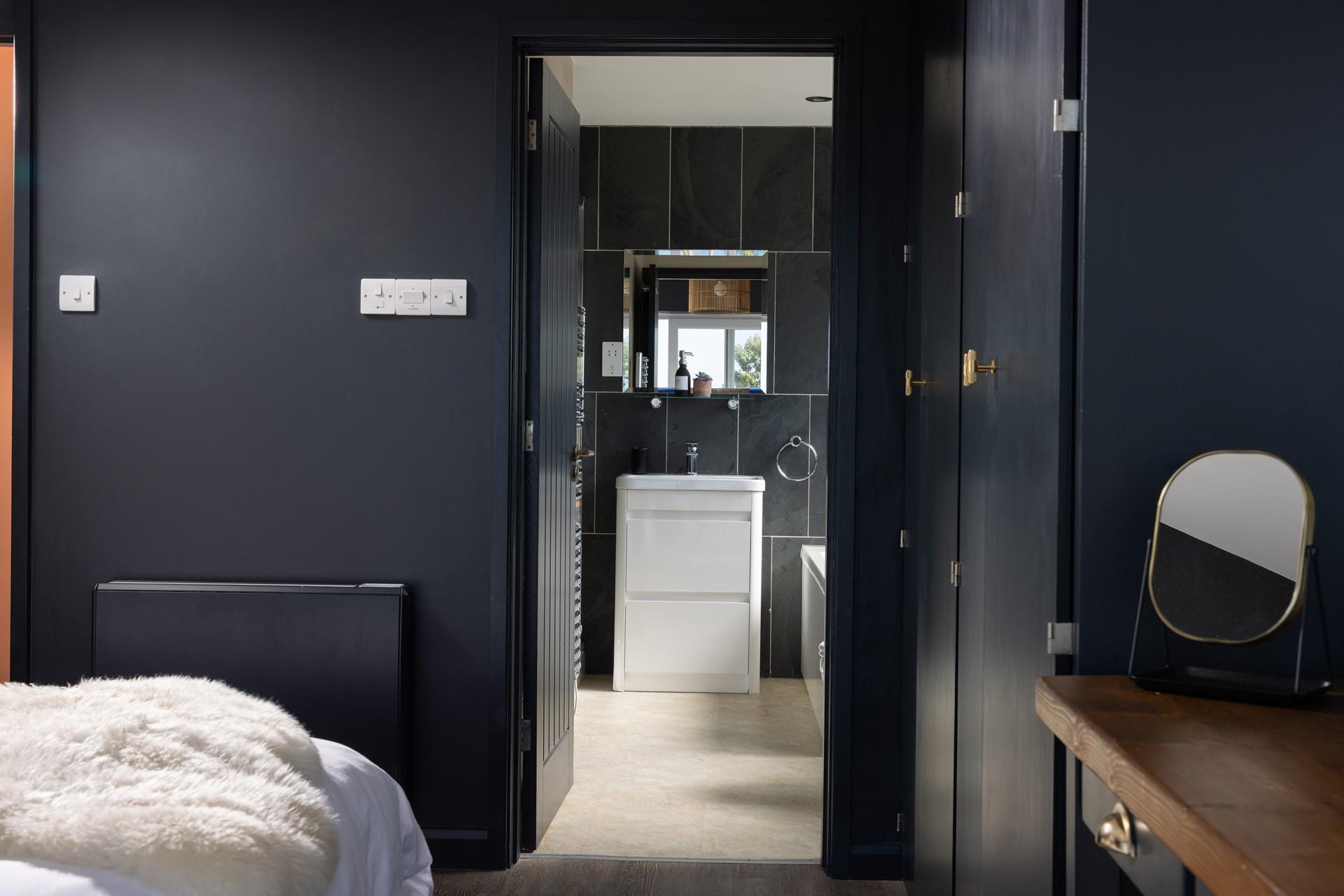 Step into the modern en suite bathroom for a refreshing shower.