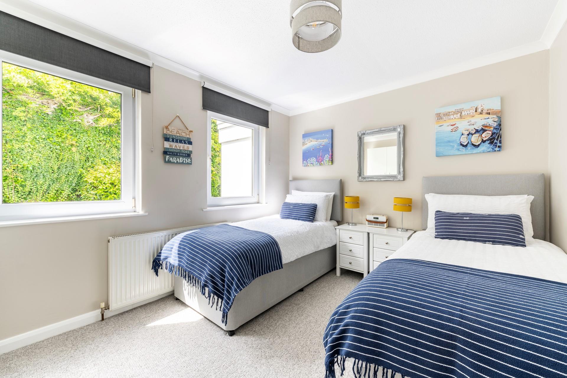 Bedroom 2 is decorated with sea blues and Cornish landscapes.