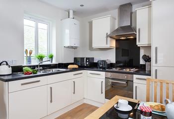 The kitchen is sleek and fully equipped with modern appliances, making it an absolute dream to cook in!