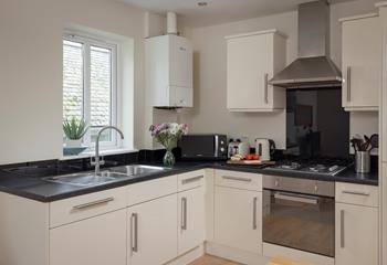 The kitchen is sleek and fully equipped with modern appliances, making it an absolute dream to cook in!