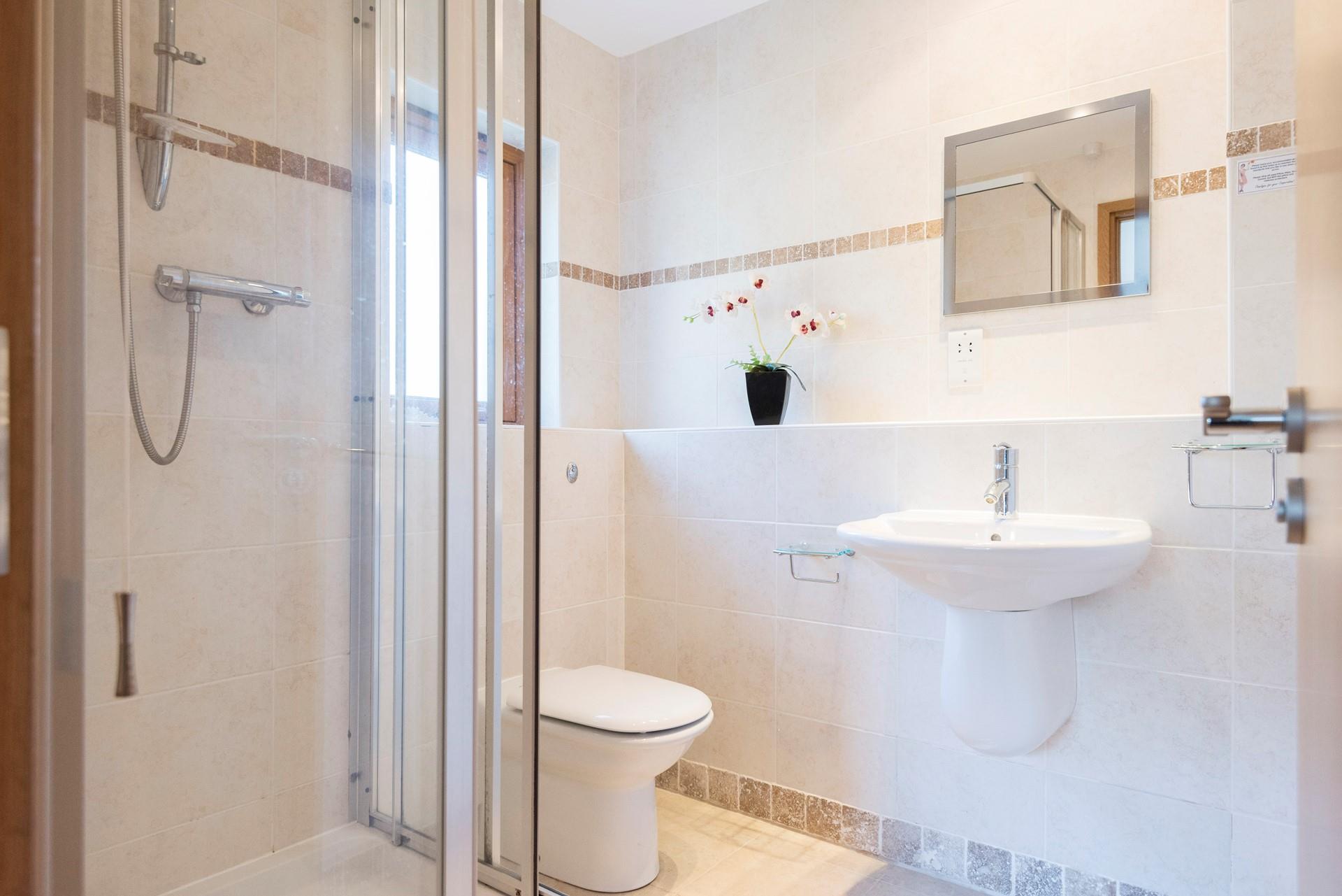 The bedroom has a modern en suite, allowing for additional space and privacy to get ready for the day.