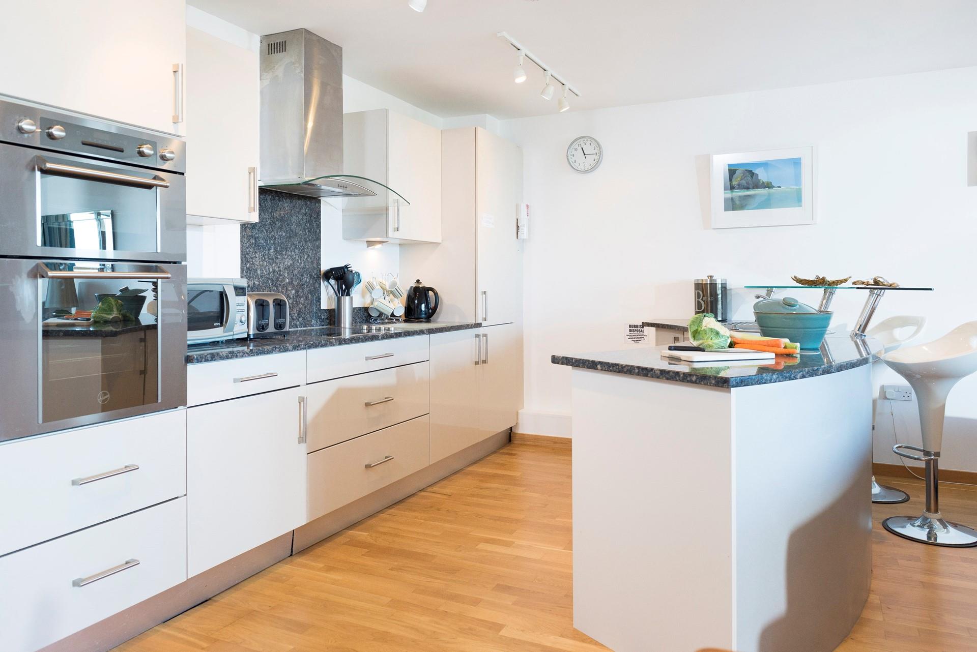 The sleek kitchen is well-equipped with modern appliances making it a joy to whip up family meals in.