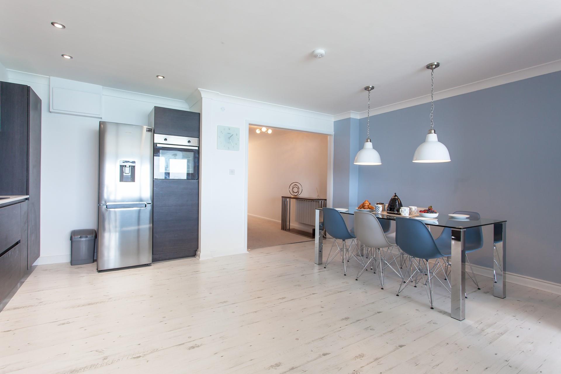 Modern and spacious, the kitchen features a stylish glass table and many mod-cons. 