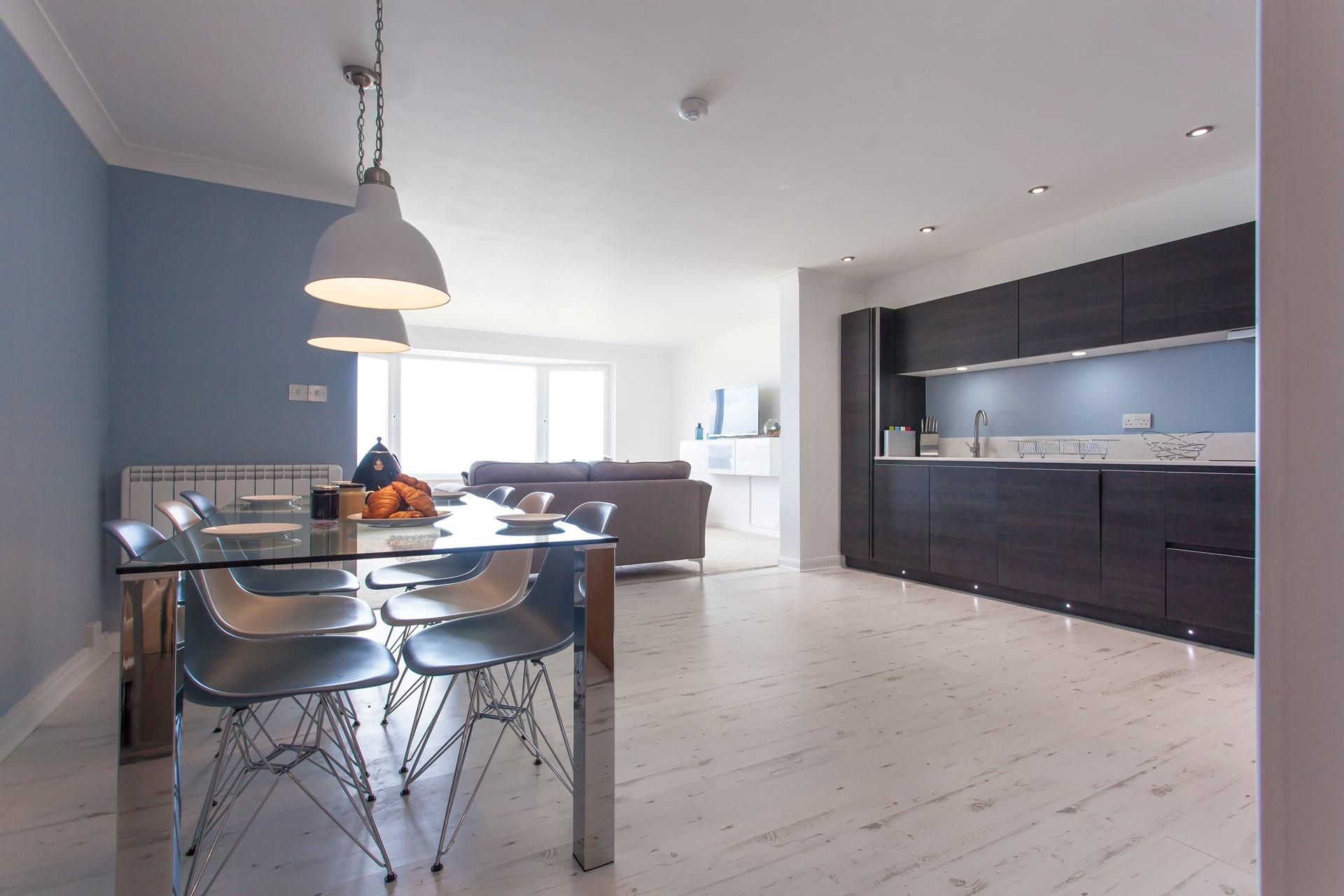 The contemporary kitchen benefits from the light streaming through the open plan living area. 