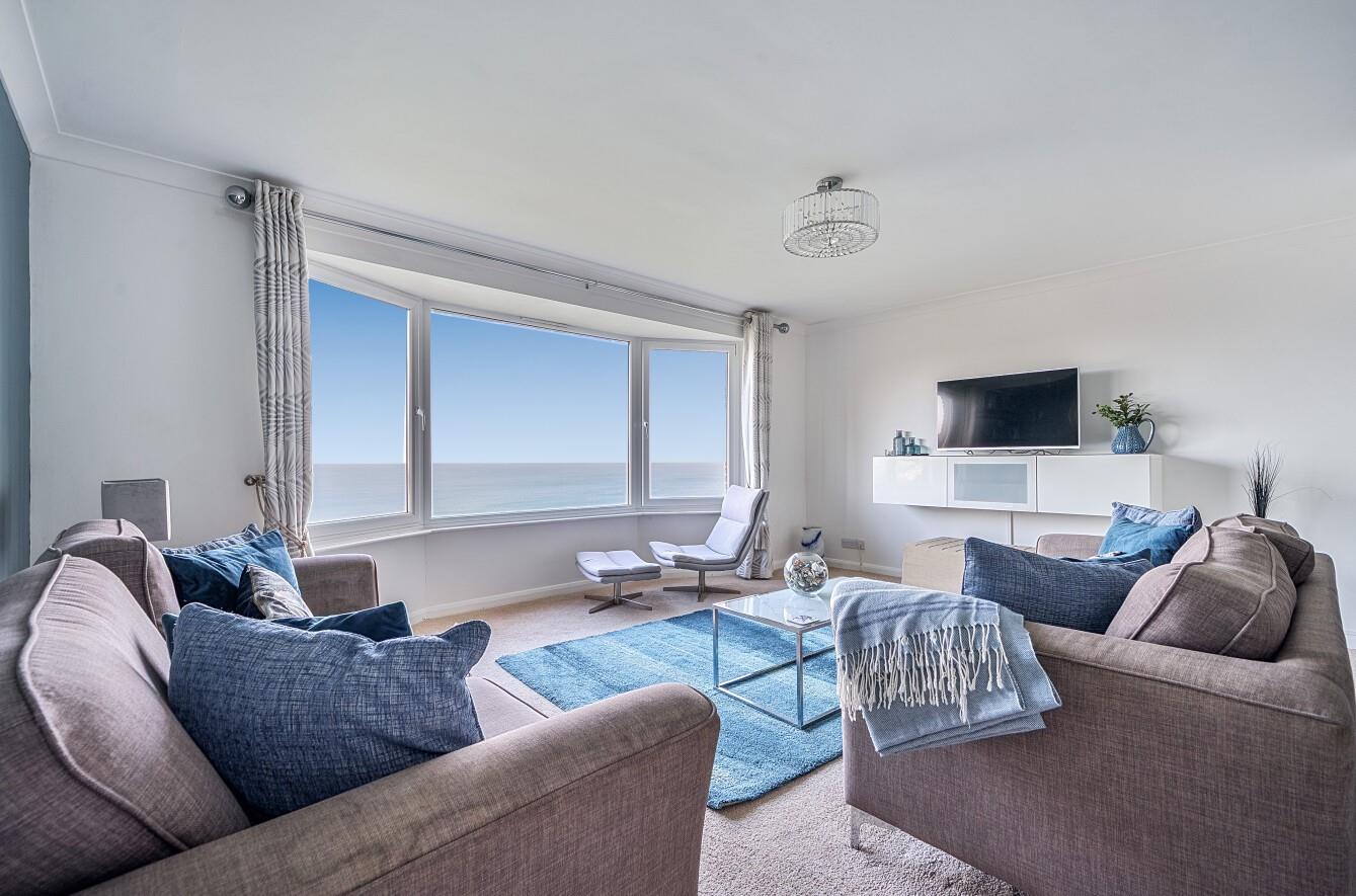 Cool blues and calming creams create a truly relaxing oasis of calm in the living area, framing the endless sea view.