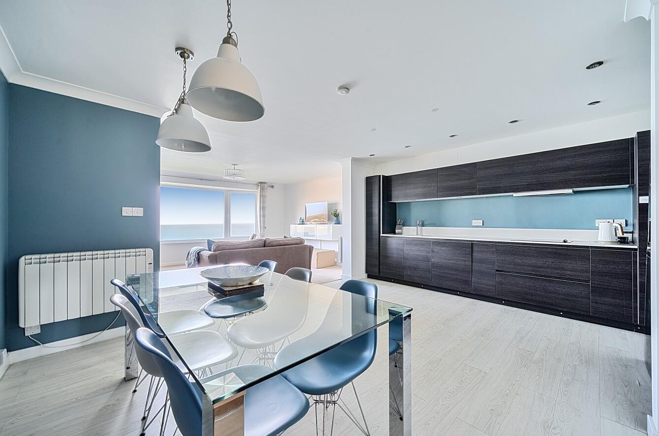 Modern and spacious, the kitchen features a stylish glass table and many mod-cons.
