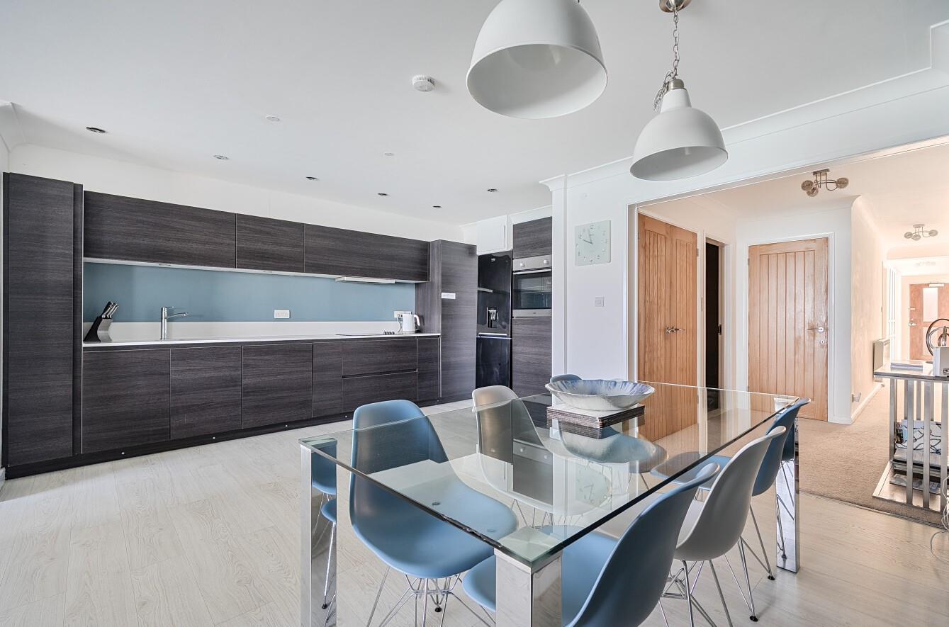 The contemporary kitchen benefits from the light streaming through the open plan living area.