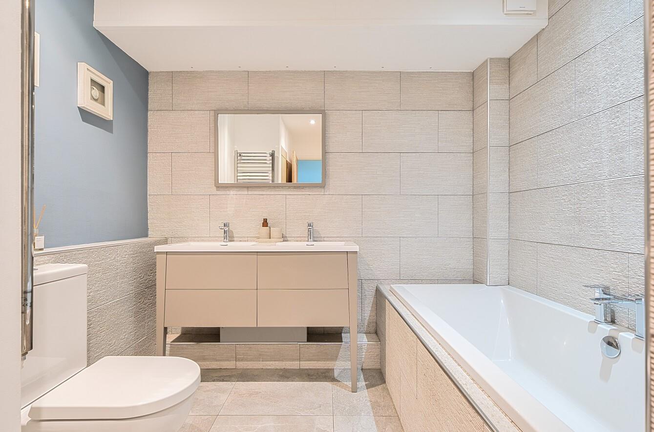 The family bathroom has a beautiful, sleek and stylish finish. 