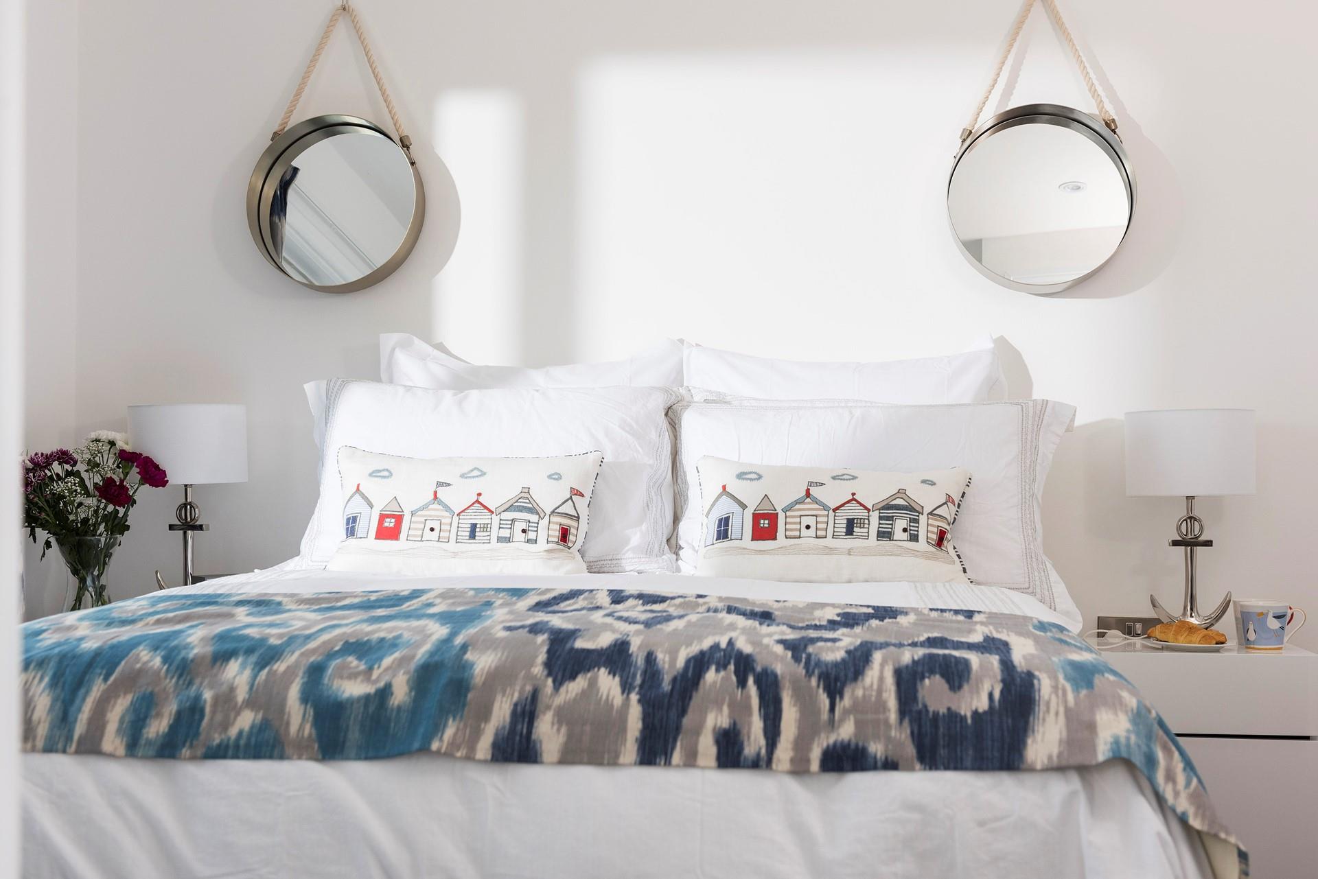 We love the nautical mirrors that add symmetry to the bedroom.