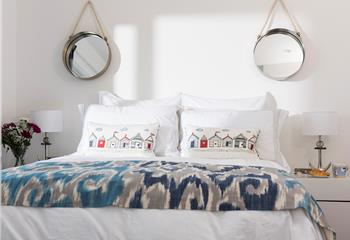 We love the nautical mirrors that add symmetry to the bedroom.