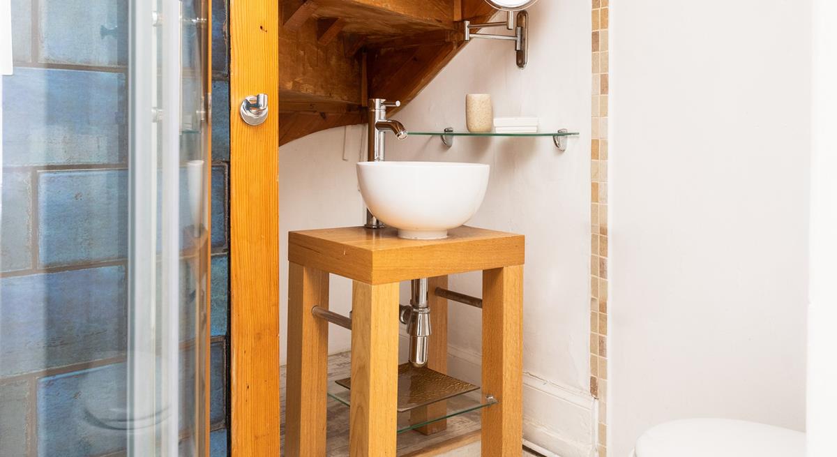 The en suite bathroom has a quirky sink and a shower.