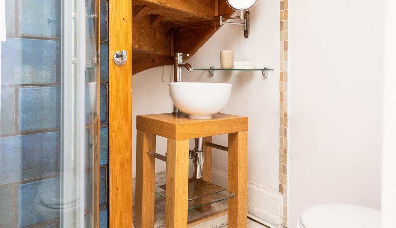 The en suite bathroom has a quirky sink and a shower.