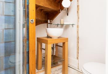 The en suite bathroom has a quirky sink and a shower.