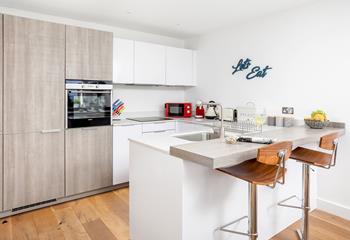 Modern and well-equipped, the kitchen benefits from a breakfast bar for casual dining. 