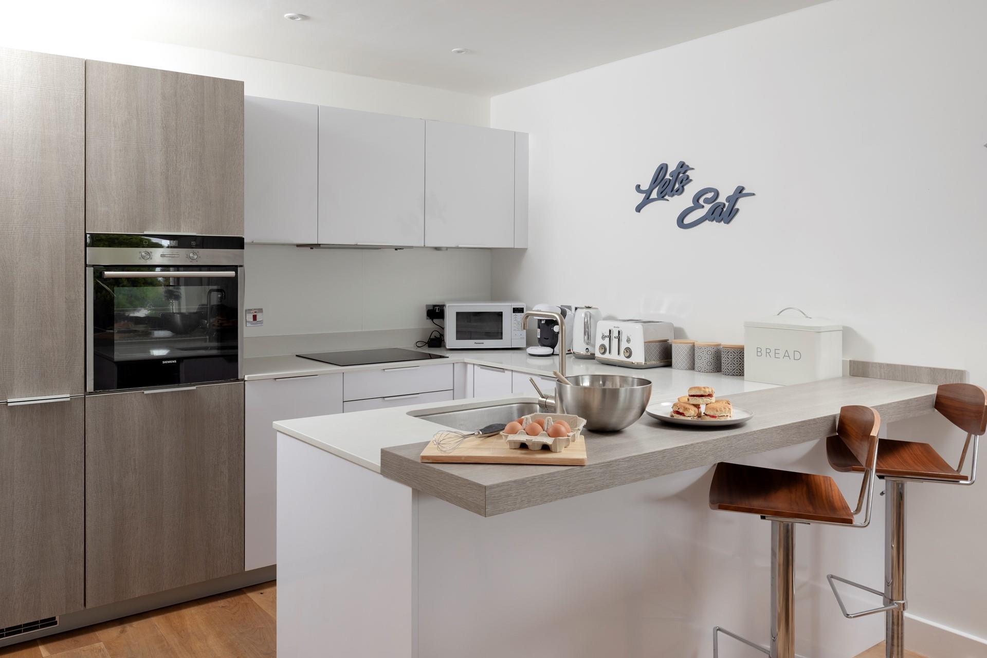 Modern and well-equipped, the kitchen benefits from a breakfast bar for casual dining. 