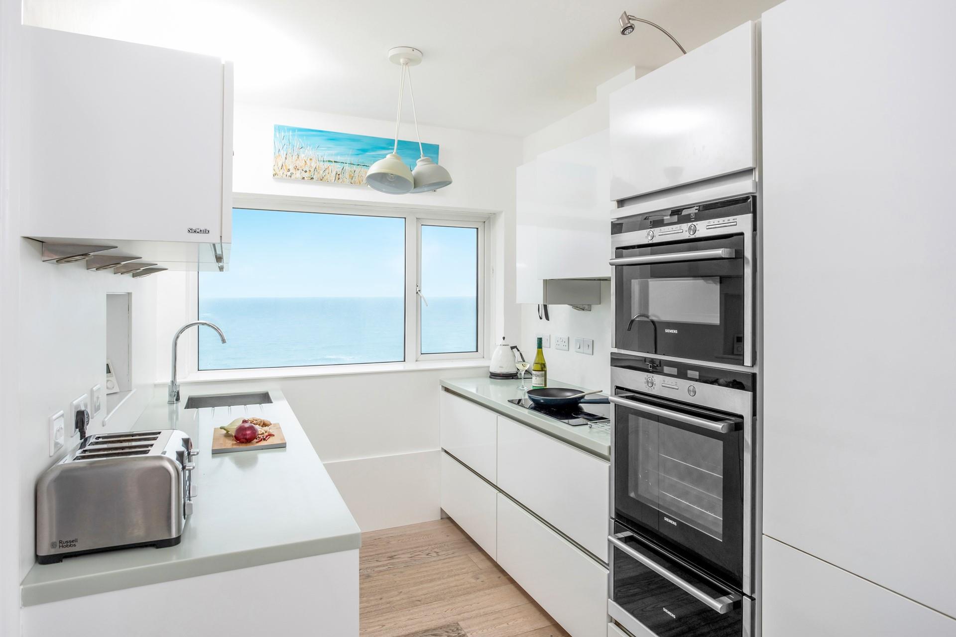 Sleek, modern and well-equipped, the kitchen is a delight to cook in with stunning views.