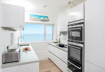 Sleek, modern and well-equipped, the kitchen is a delight to cook in with stunning views.