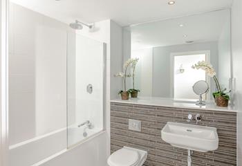 The en suite has a fresh, modern feel and provides space and privacy to get ready.