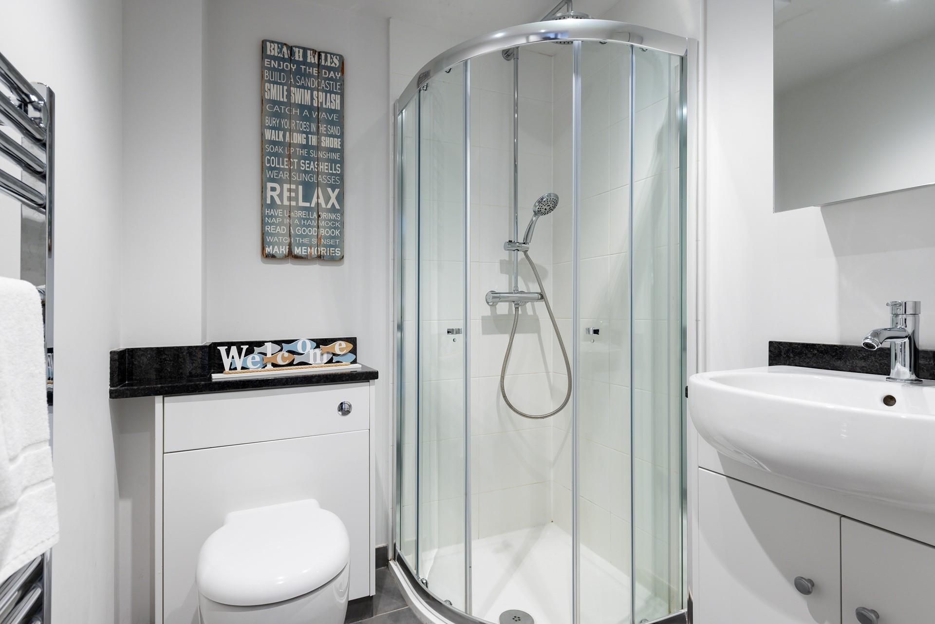 The bathroom is modern and functional with touches of quirky decor.