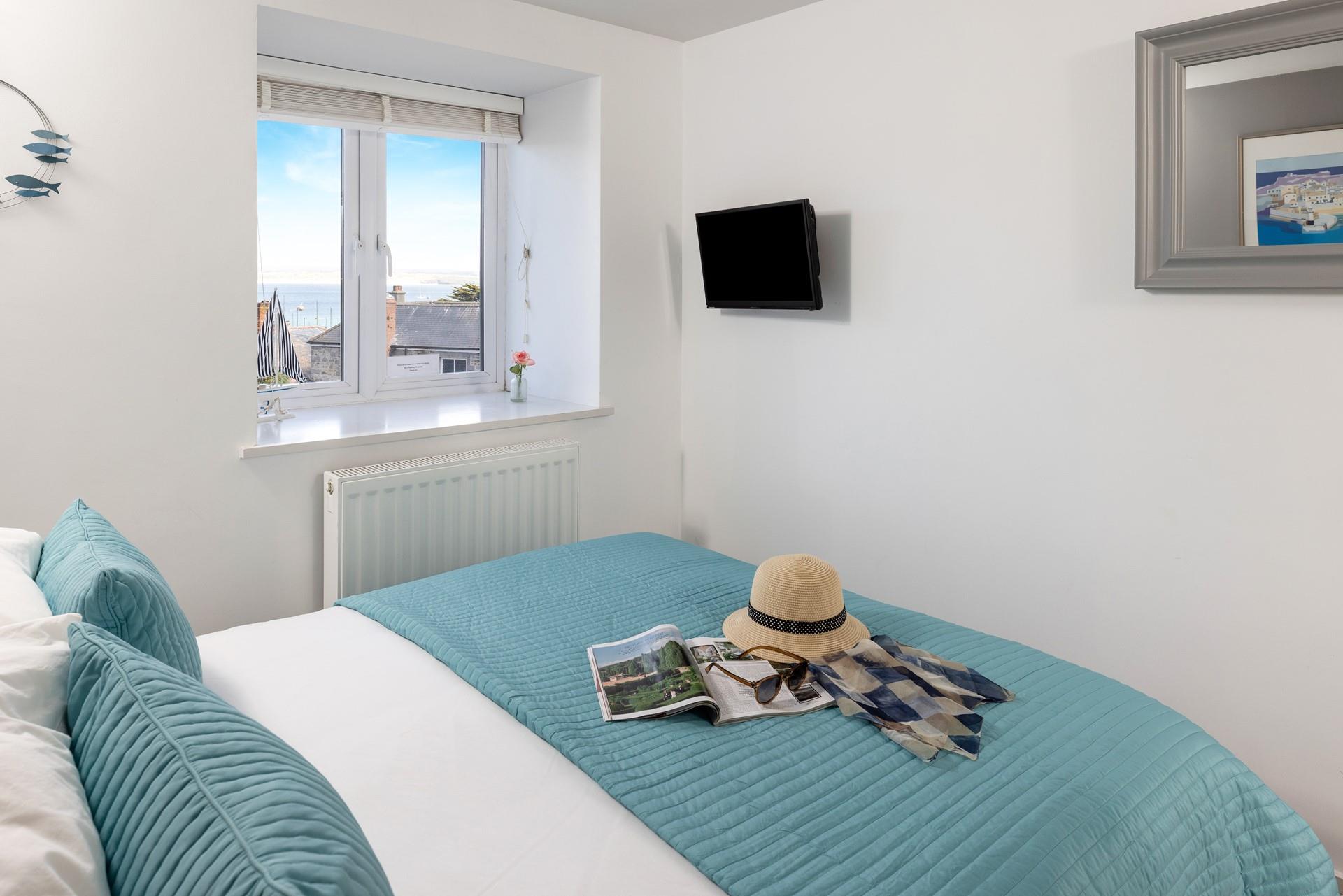 The bedroom offers sea views over the rooftops.