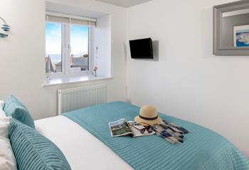 The bedroom offers sea views over the rooftops.