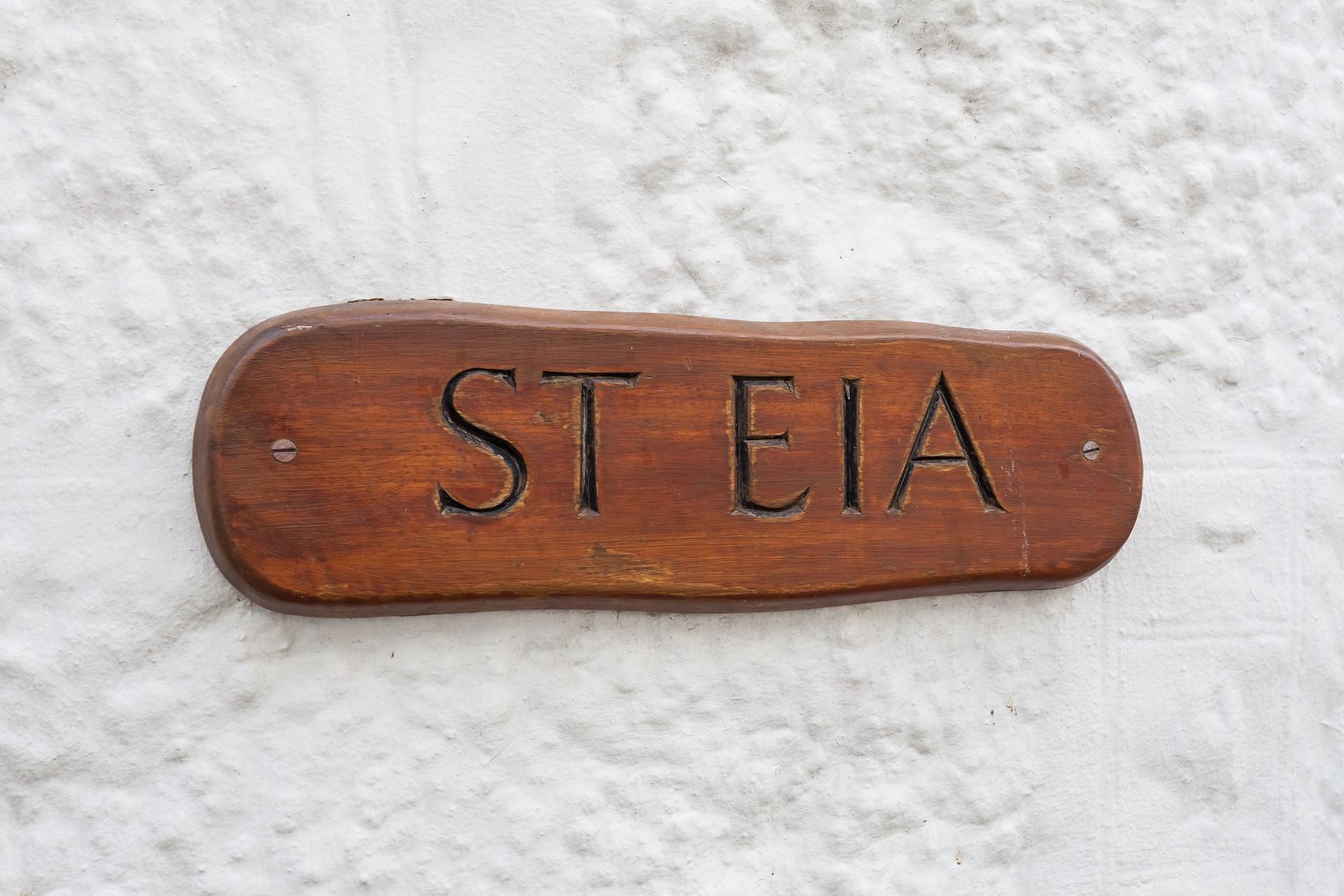 The cottage has a traditional whitewashed exterior and the wooden property sign looks great.