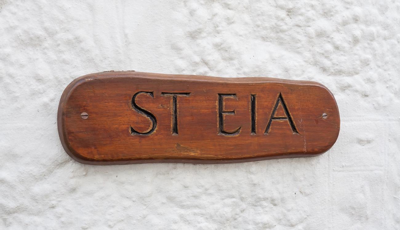 The cottage has a traditional whitewashed exterior and the wooden property sign looks great.