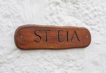 The cottage has a traditional whitewashed exterior and the wooden property sign looks great.