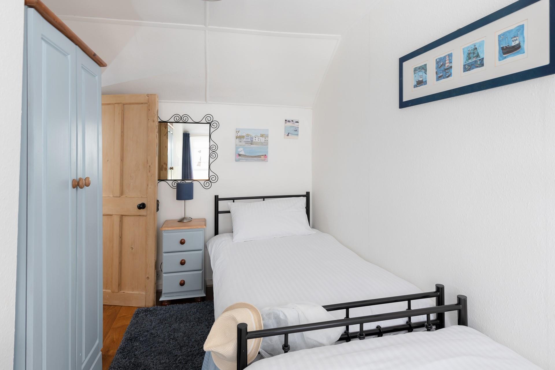 Twin beds and fun decor make this bedroom perfect for kids and young adults.