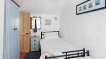 Twin beds and fun decor make this bedroom perfect for kids and young adults.