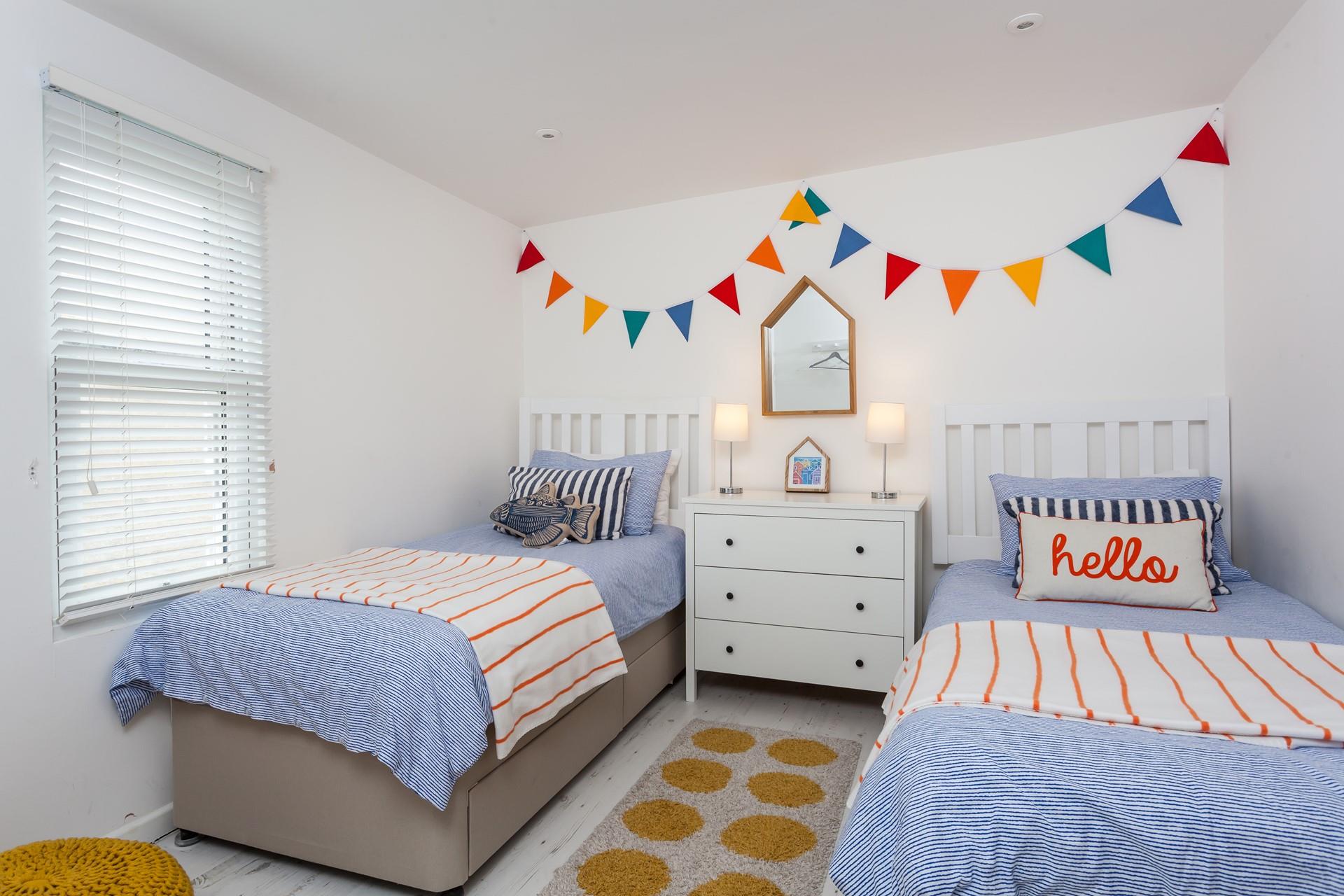 Bedroom 3 has twin beds and is colourfully decorated.