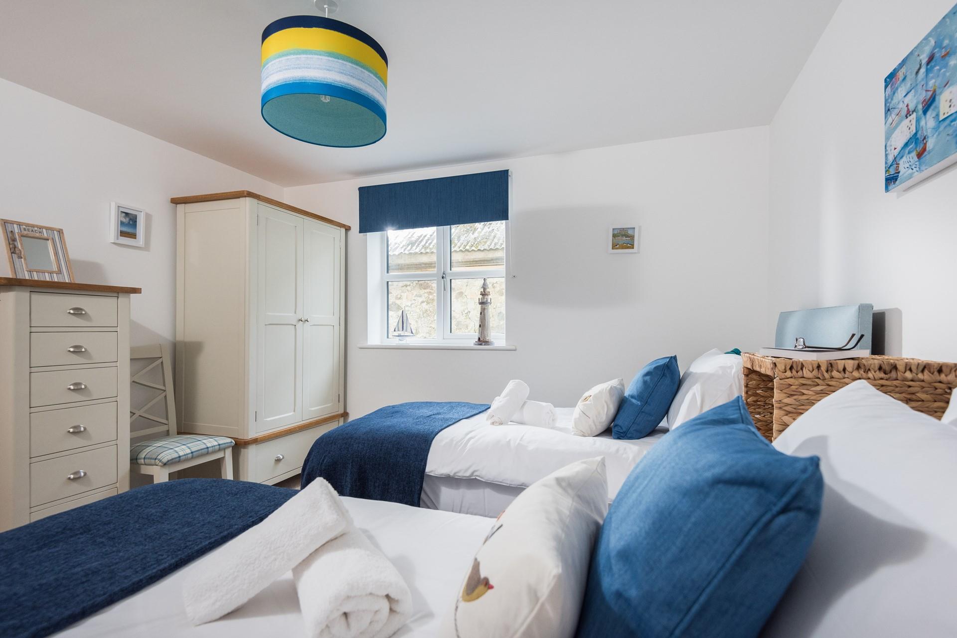 Finished with coastal decor, the twin room is the perfect place to rest after a day at the beach.