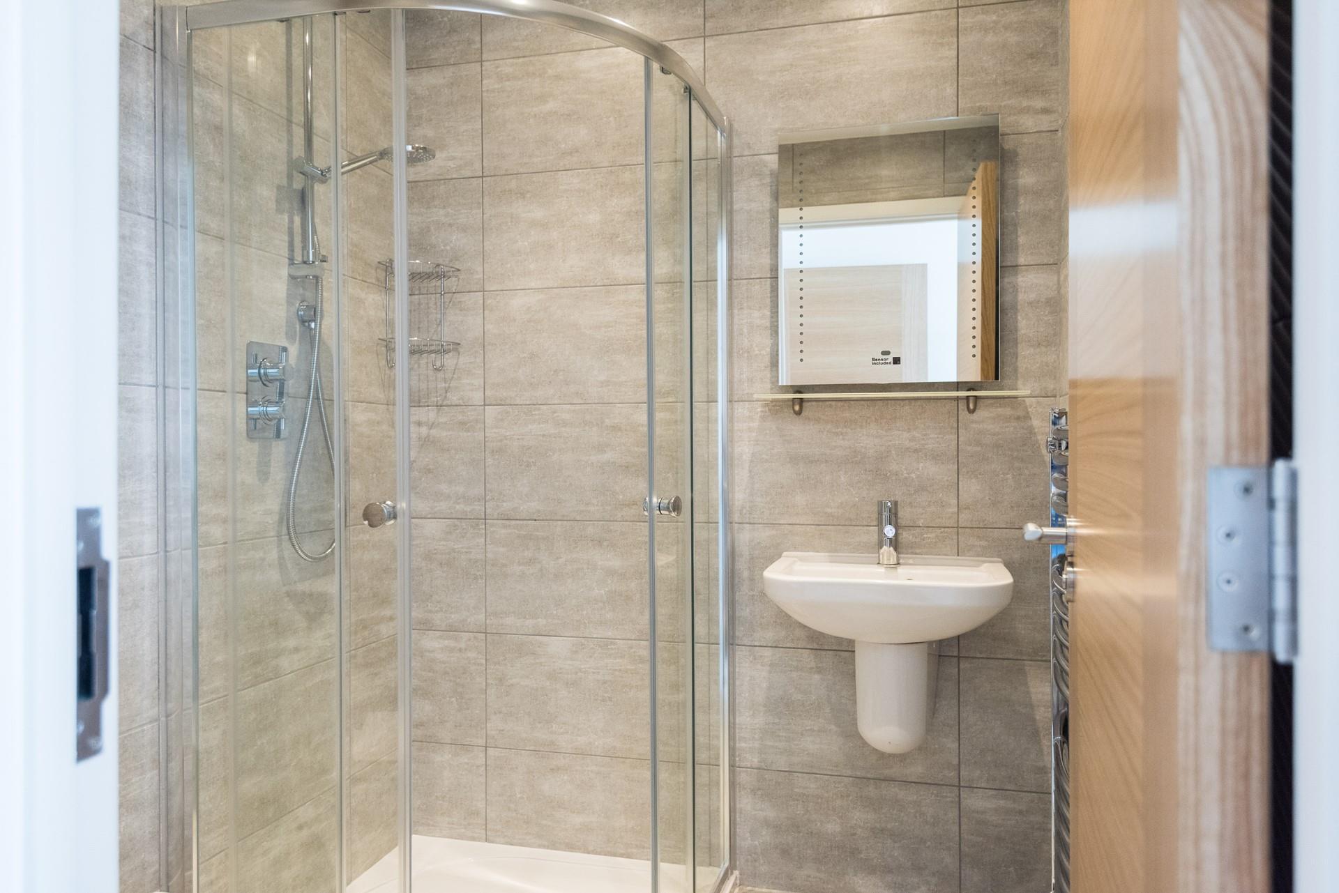 A large shower, basin, WC, and heated towel rail complete the en suite. 
