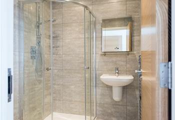 A large shower, basin, WC, and heated towel rail complete the en suite. 
