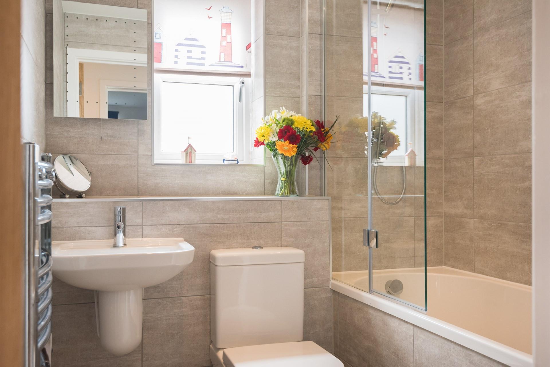 The family bathroom has a bath with a shower overhead, ideal for the whole family.