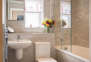 The family bathroom has a bath with a shower overhead, ideal for the whole family.